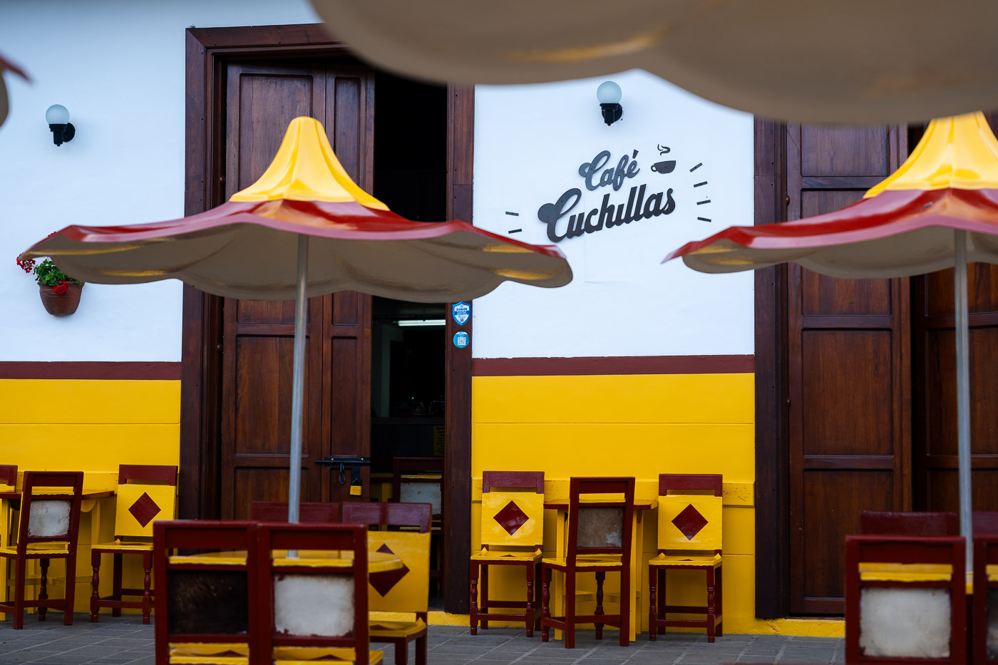 The yellow, white and red exterior for Cafe Cuchillas in Jardin main square.