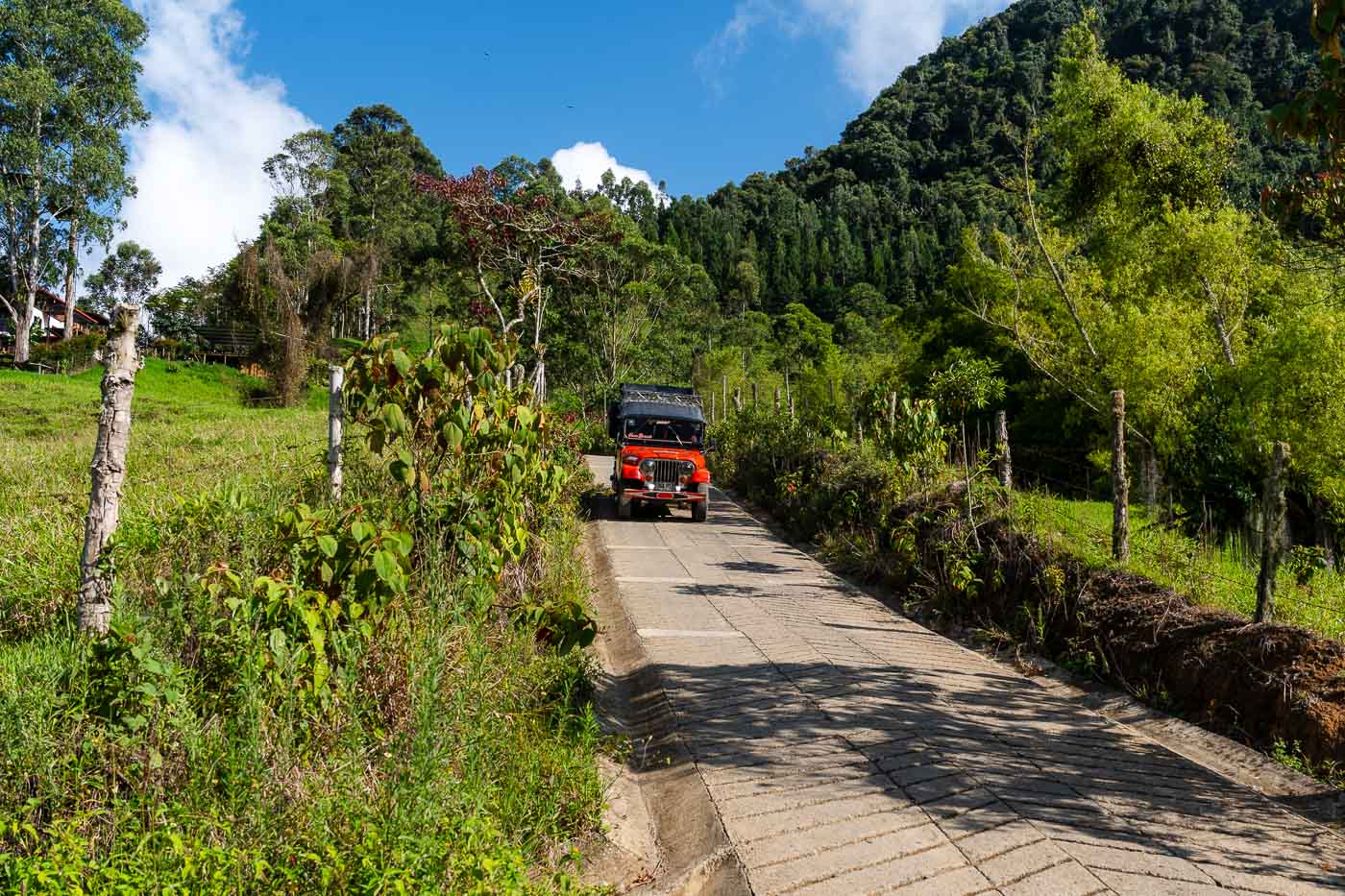 A red jeep descending down a hill in the mountains surrounding Jardin.