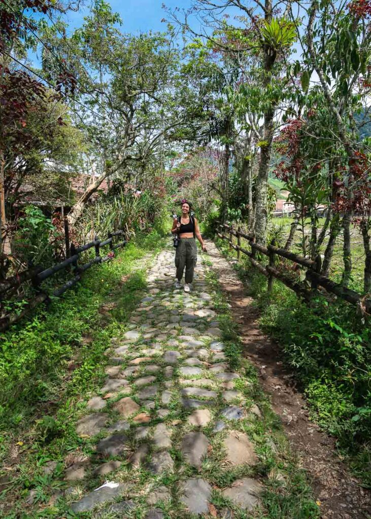 Sara walking along the cobblestones of the Camino de la Herrera towards Cascada del Amor in Jardin.