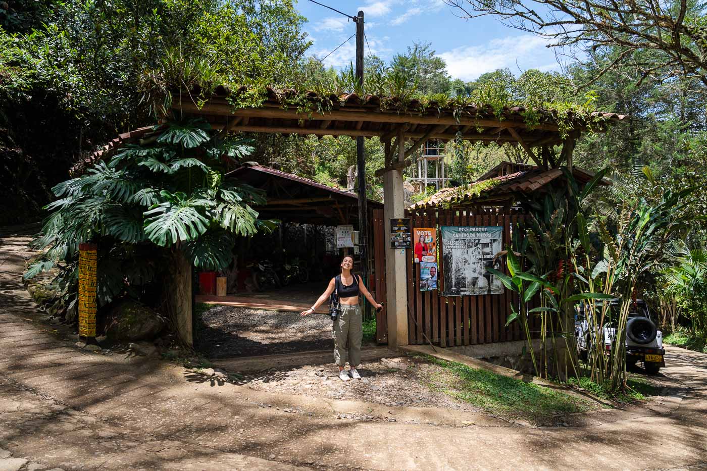 Sara posing on the road outside the wooden entrance gate to Cueva de los Murcielagos.