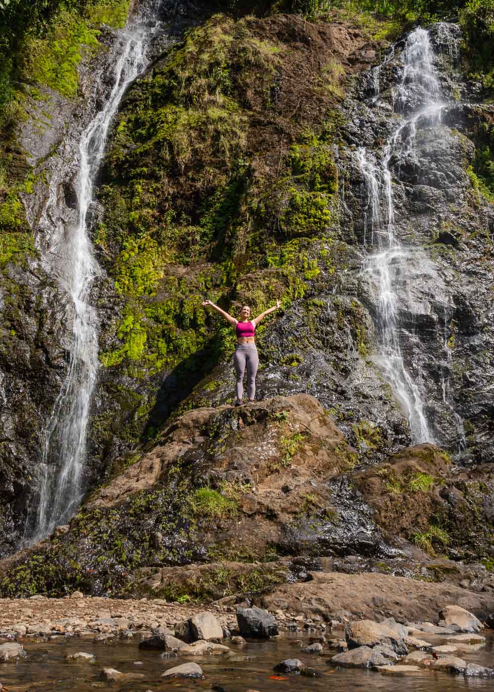 Sara happy-posing on a rock in the middle of Cascada la Escalera's two cascades.
