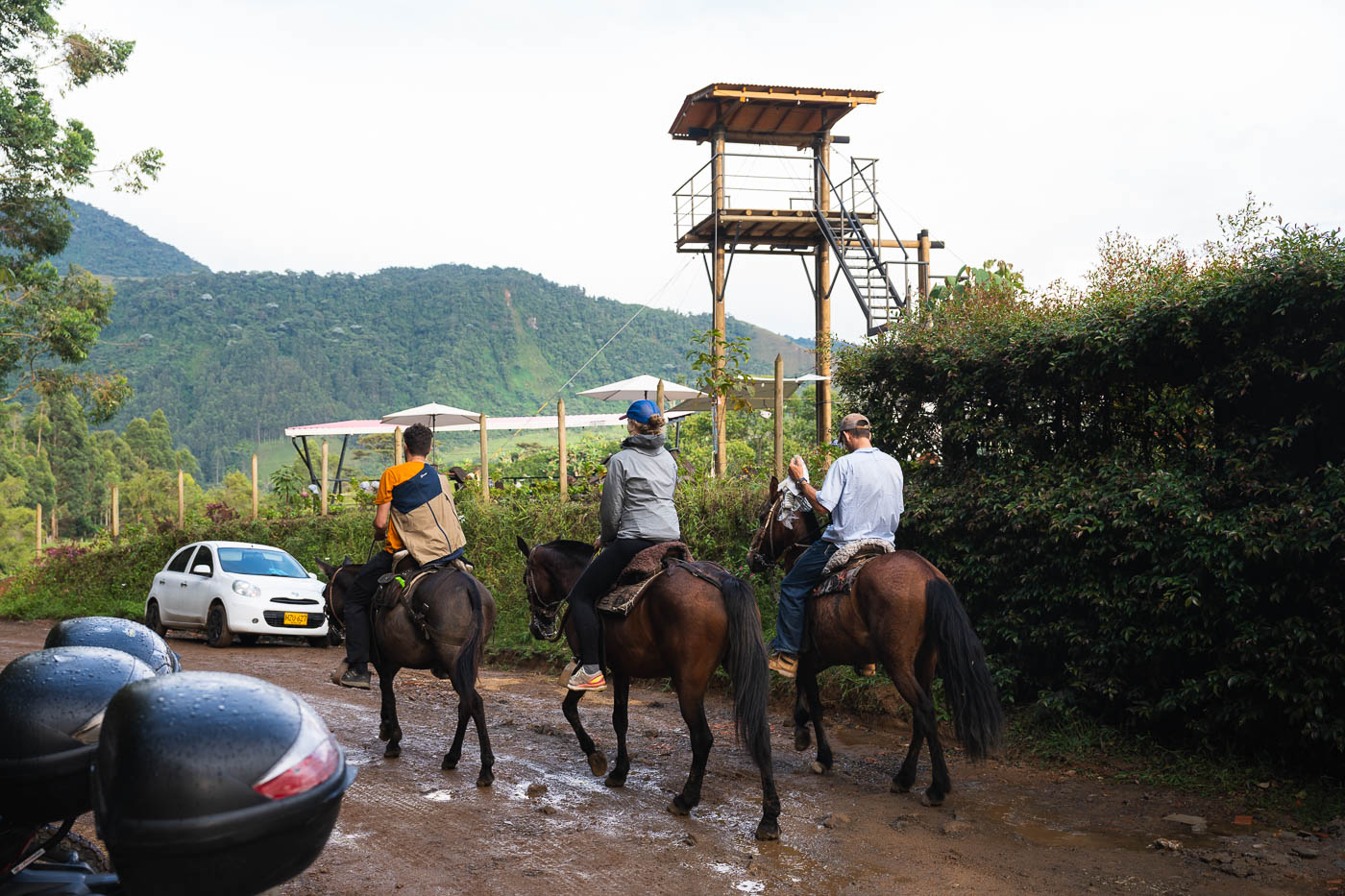 Three horse riders riding down a muddy dirt track near Jardin after it rained.
