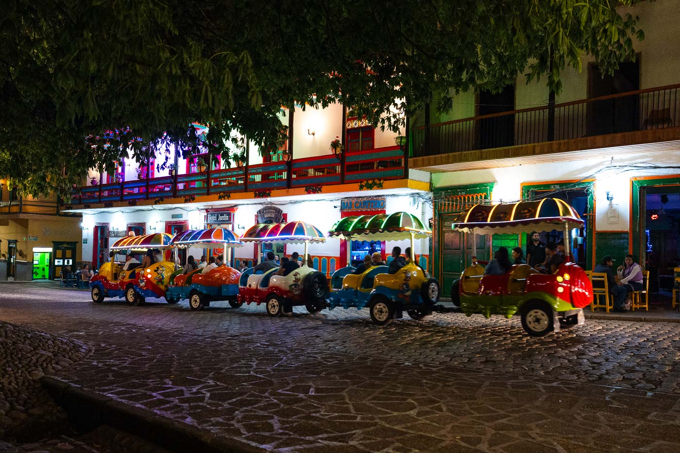 A colourful trail driving around at night in Plaza de Libertador in Jardin.