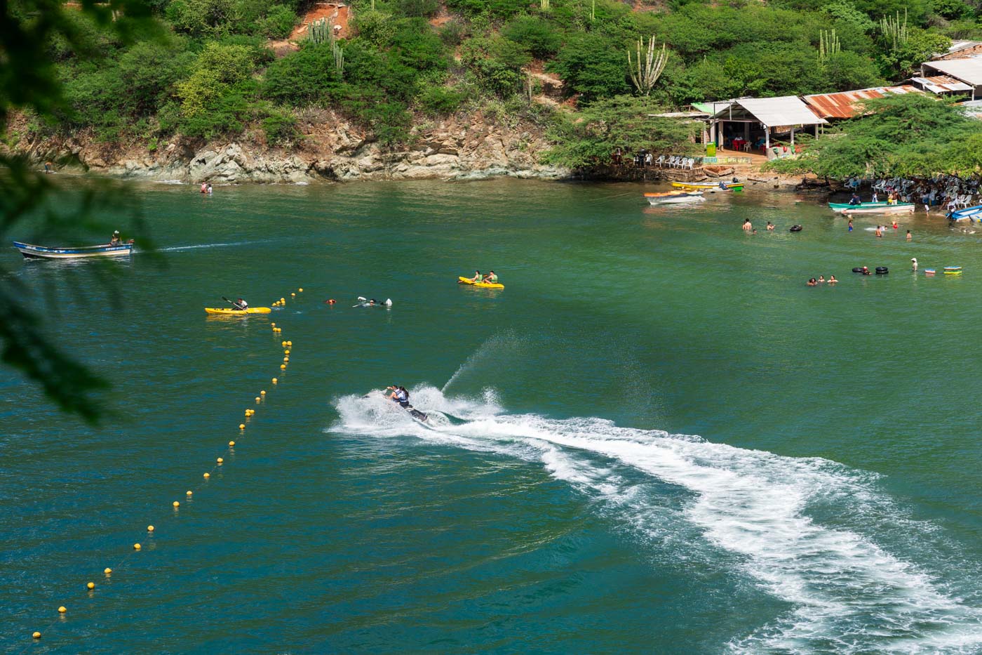A jet skier making a tight turn besides some kayakers at Playa Grande.