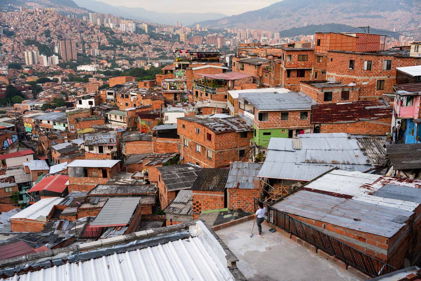 A Comuna 13 resident standing on the roof of her house looking over all the favelas across Comuna 13.