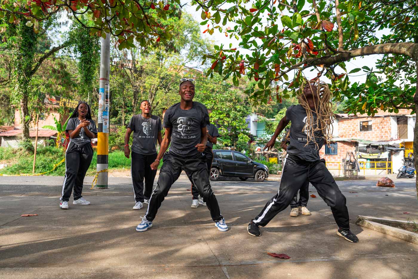 A local Afro-Caribbean dance troupe dancing together under a tree.