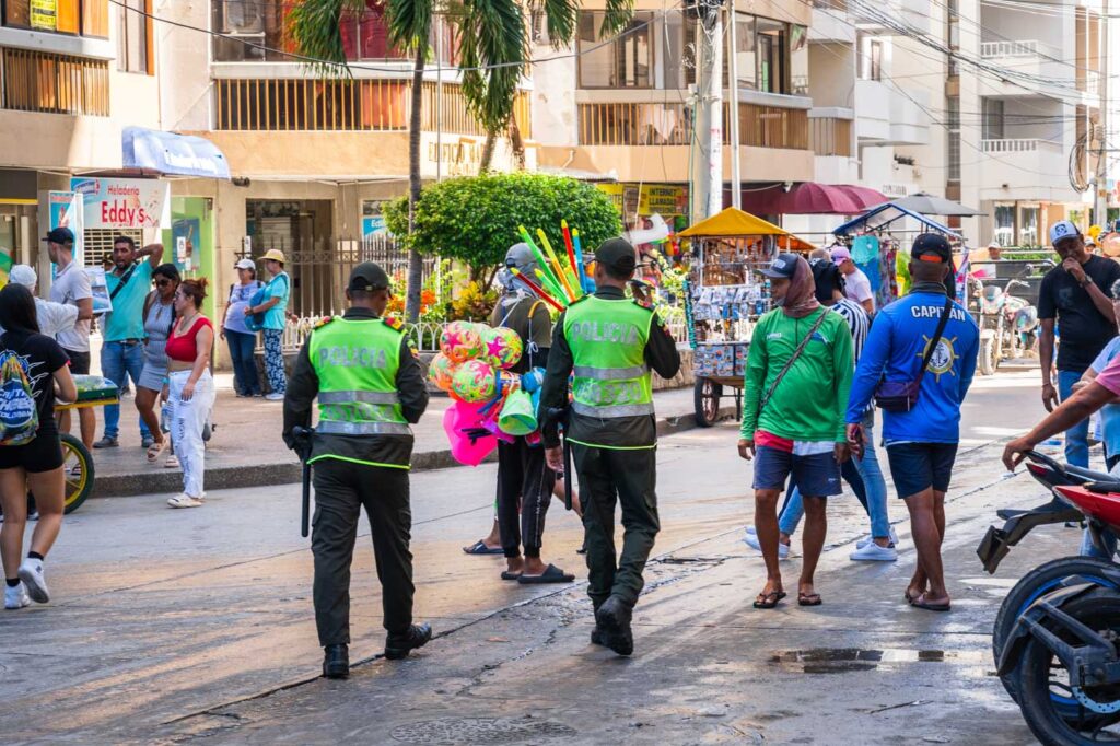 Police patrolling the streets surrounded by tourists and vendors.