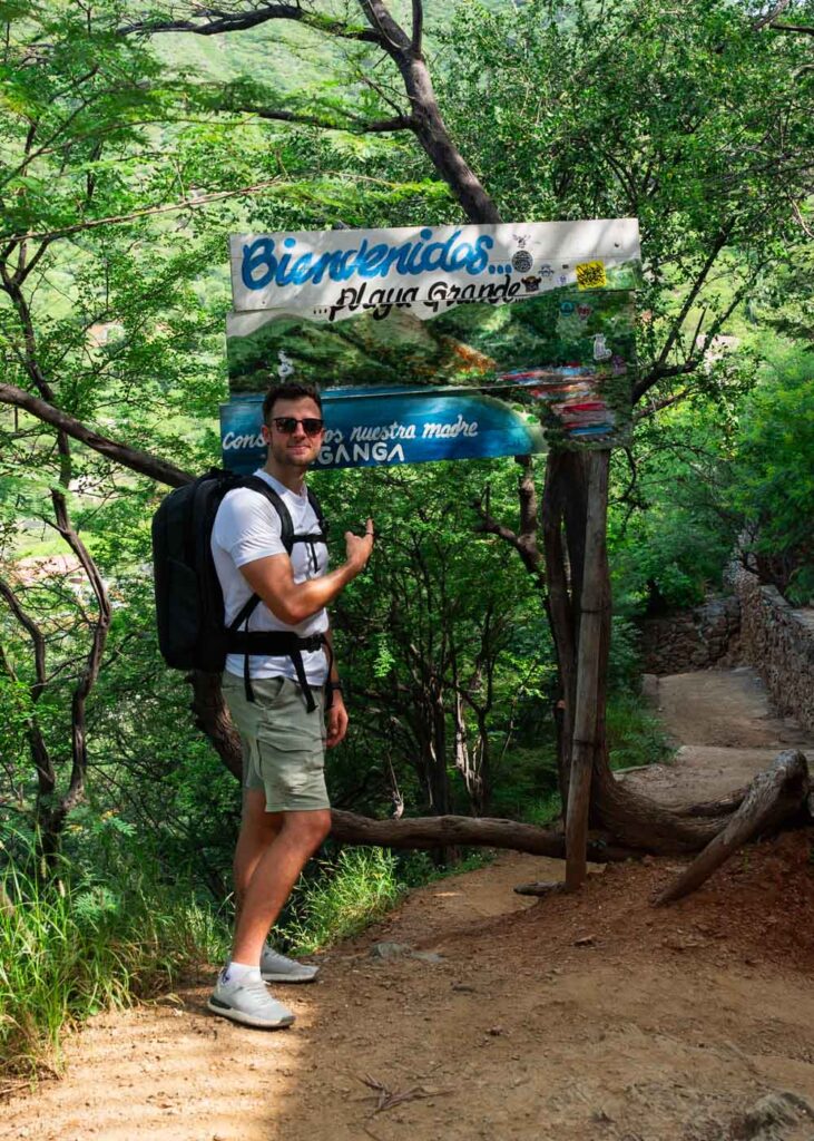 Ryan posing besides the Welcome to Playa Grande sign.