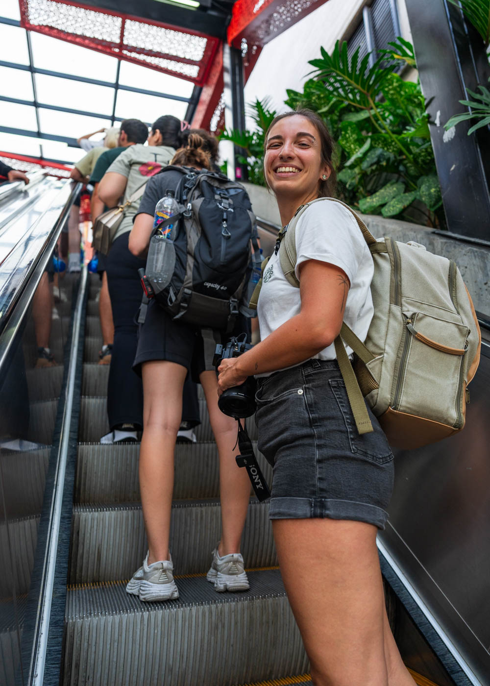Sara smiling at the camera while riding the escalator up Comuna 13.