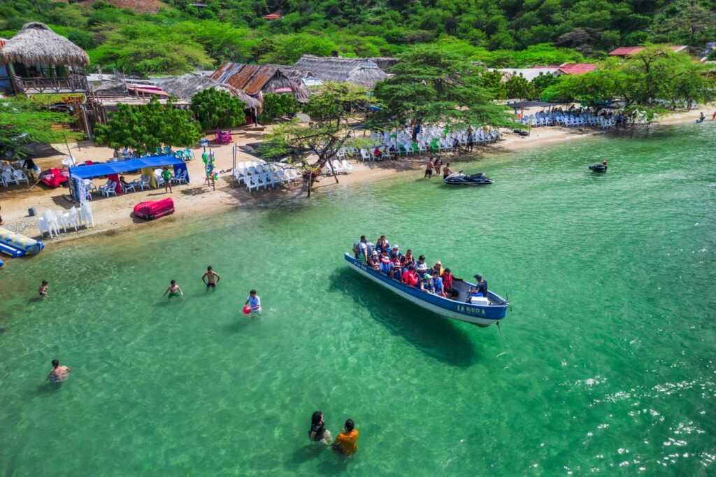 A taxi boat leaving Playa Grande while people are swimming.