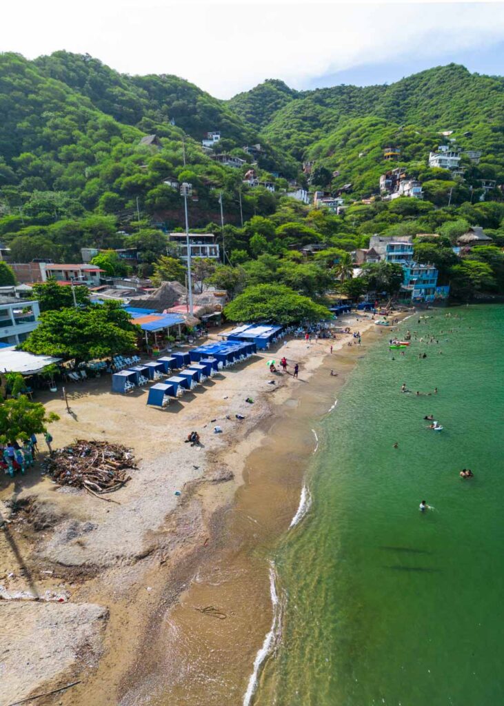 Playa Taganga with tourists and tents along it.