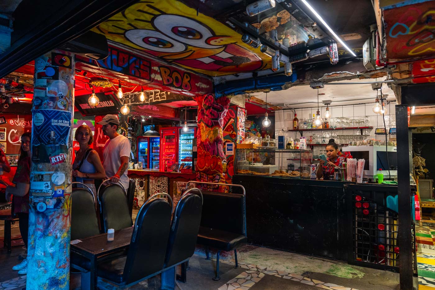 A unique looking bar with an underground aesthetic and a painting of Spongebob on the ceiling.