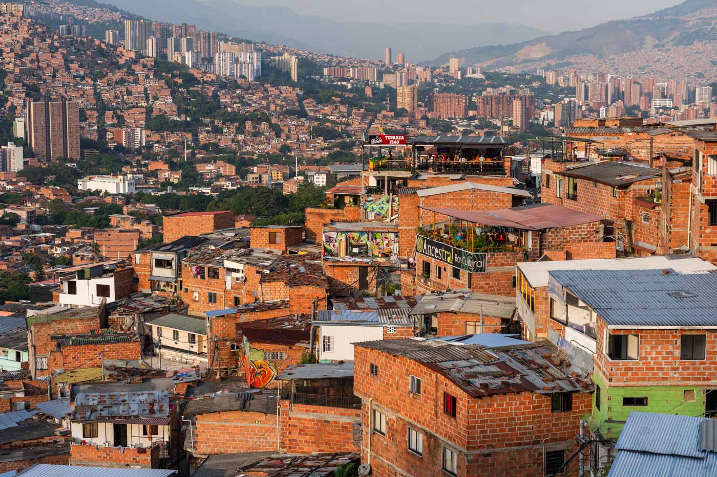 A view across Comuna 13 to a 360 degree view bar and Medellin city in the background.