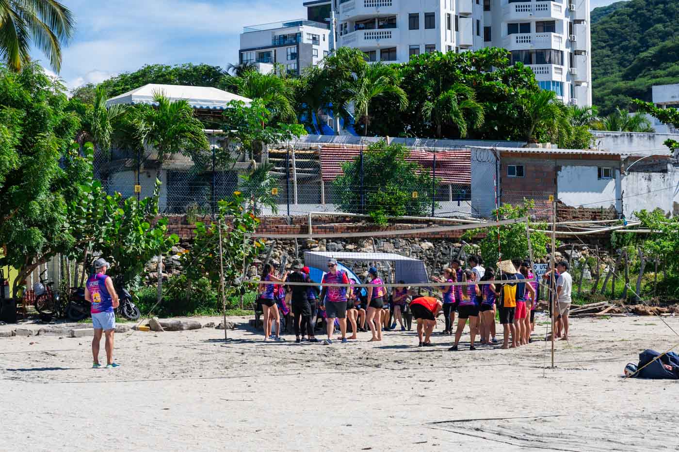 A beach volleyball team wearing pink and purple uniforms.