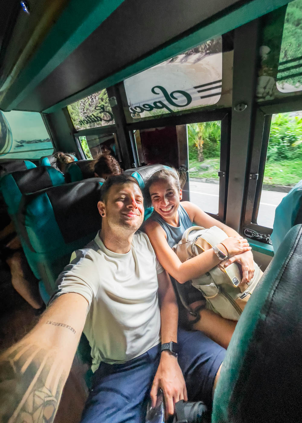 Ryan and Sara wearing hiking gear and taking a selfie on the pubic bus.