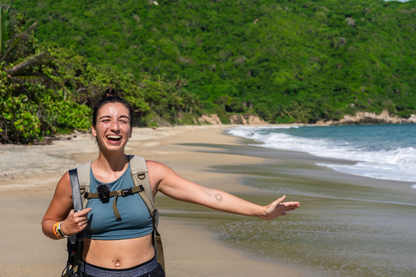 Sara posing and smiling in front of Playa Nudista in Tayrona National Park.