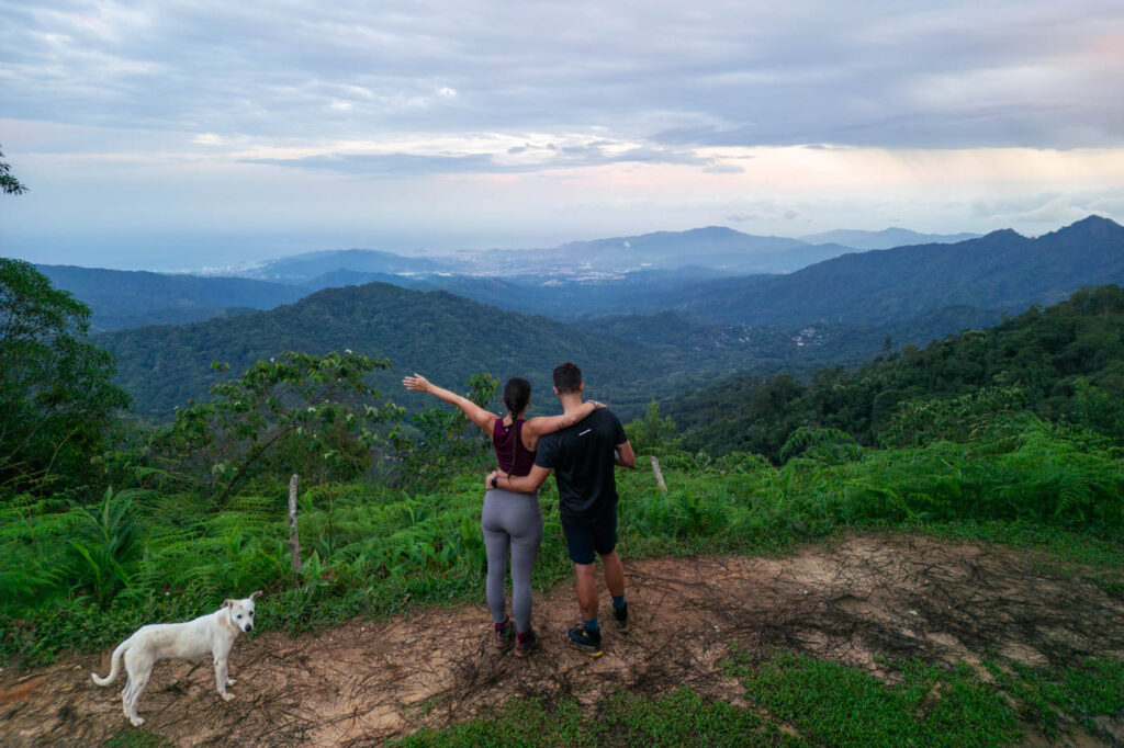 Ryan and Sara hugging at Los Pinos viewpoint overlooking Santa Marta with a white dog. Ryan and Sara hugging at Los Pinos viewpoint overlooking Santa Marta with a white dog.