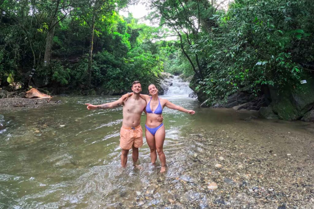 Sara and Ryan hugging and posing in front of Pozo Azul waterfall in Minca.