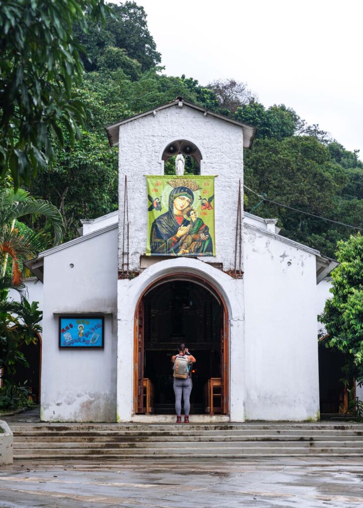 Sara standing in front of the white Church of Minca taking a photo. Sara standing in front of the white Church of Minca taking a photo.