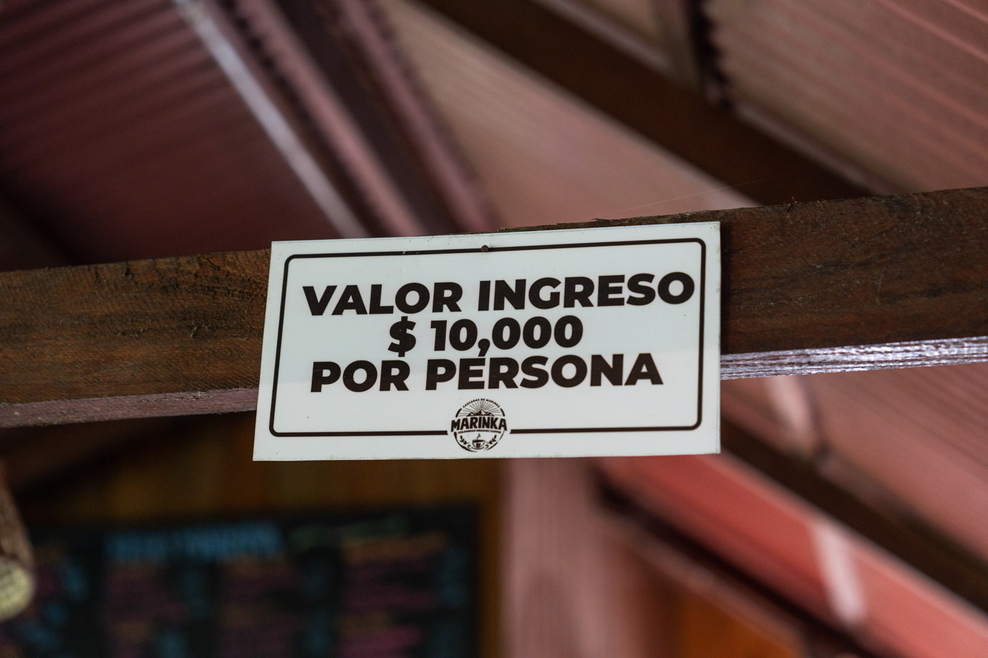 Small sign depicting the entrance fee price for Marinka Waterfalls in Spanish.