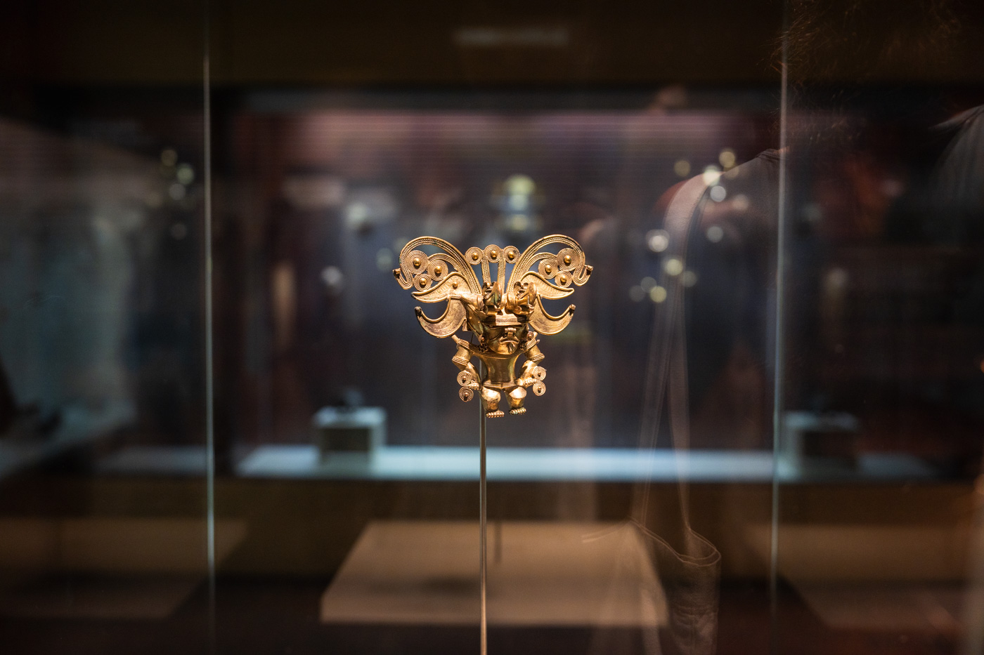An old, gold Colombian gold artefact held up by a metal rod inside the Museo del Oro in Santa Marta.