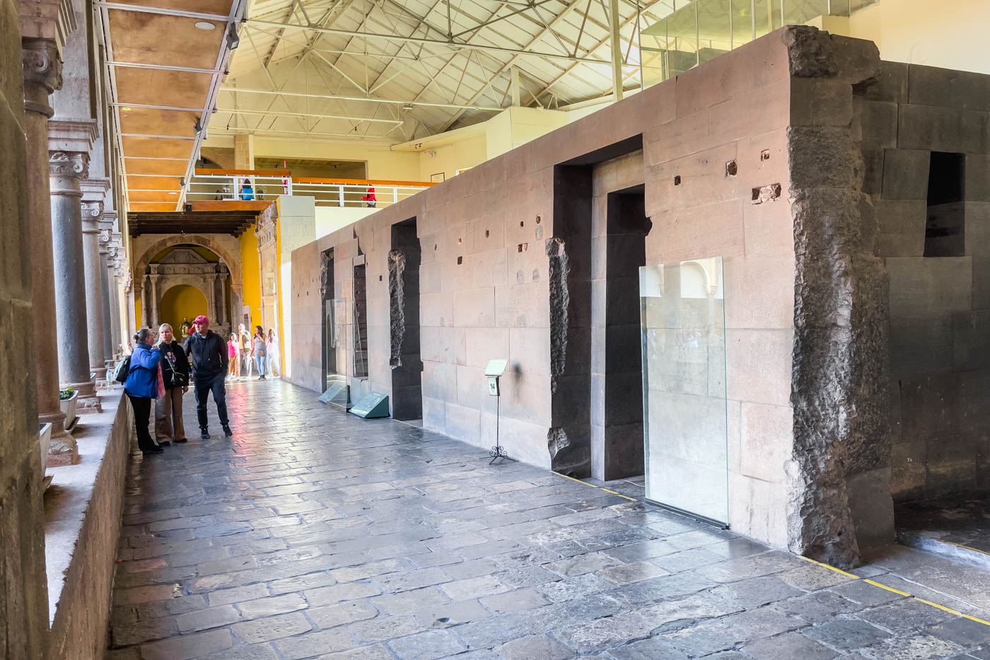 Tourists beside the ruins of the Sun Temple inside of the Iglesia y Convento de Santo Domingo in Cusco.