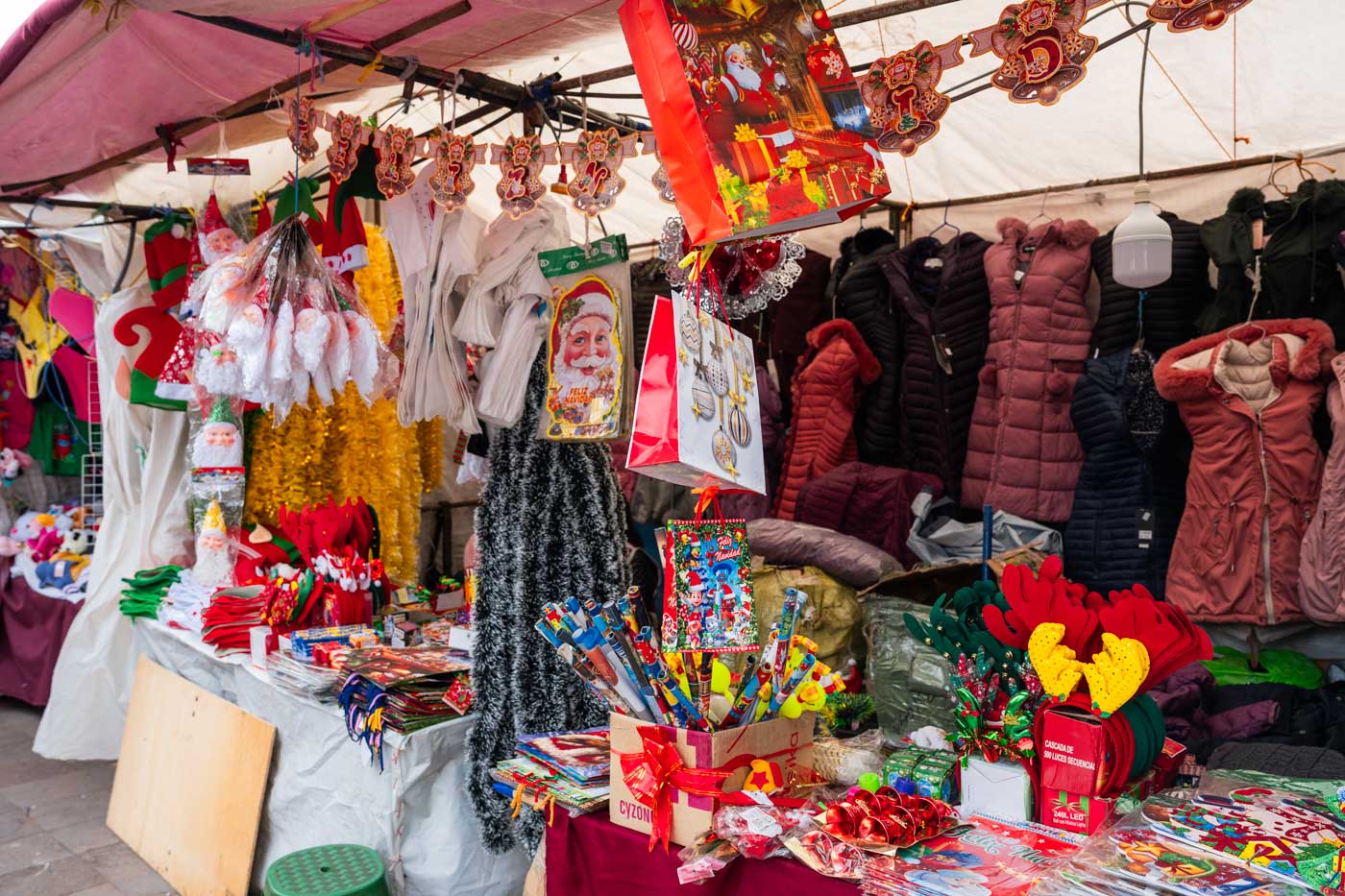 A stall outside of Mercado San Pedro selling coats, Christmas decorations and other trinkets.