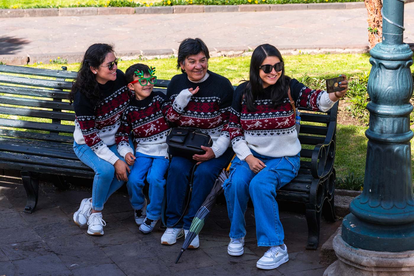 A family taking a selfie in Cusco while wearing matching red, blue and white Christmas jumpers.