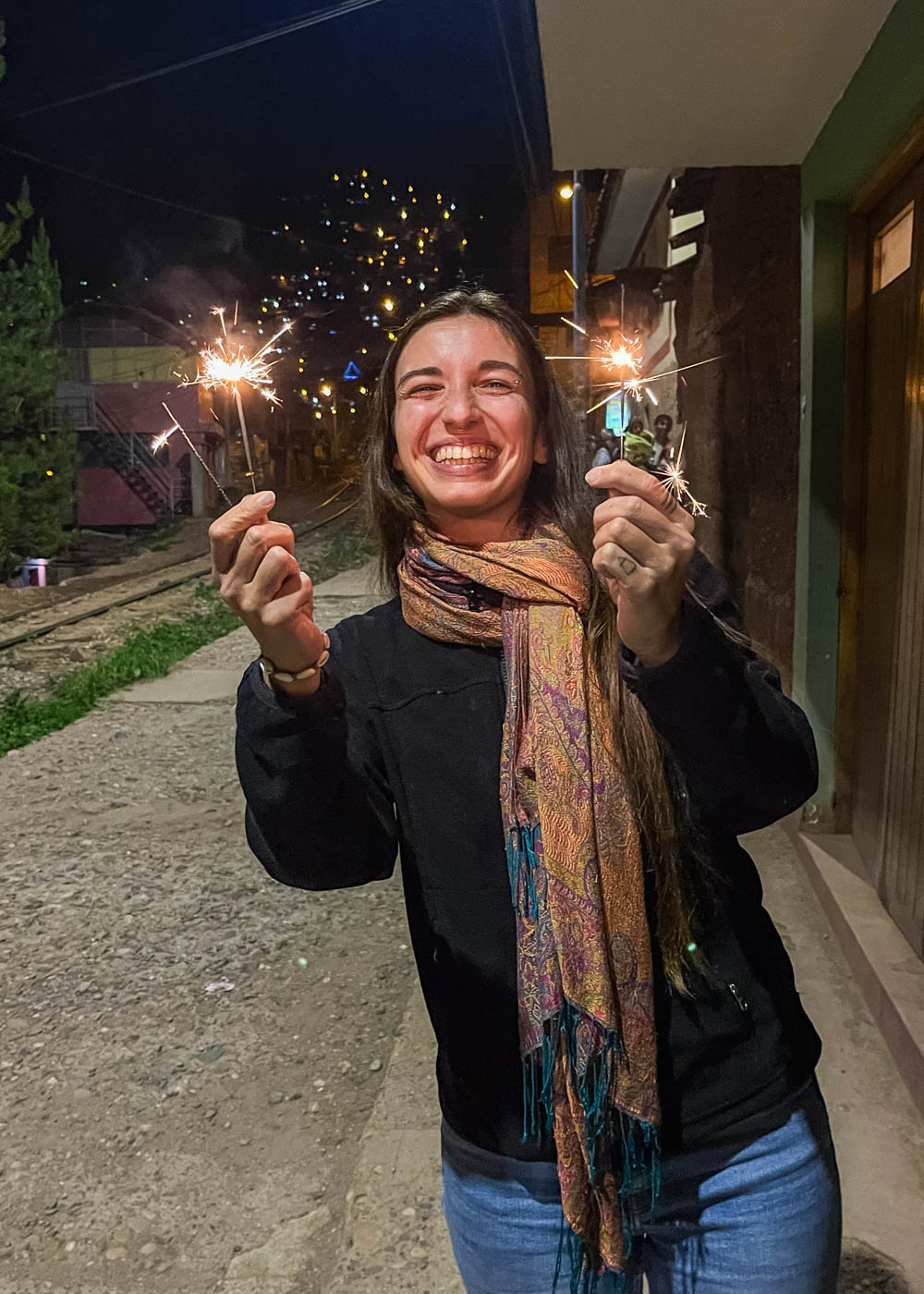 Sara smiling and holding up sparklers on Christmas Eve in Cusco.