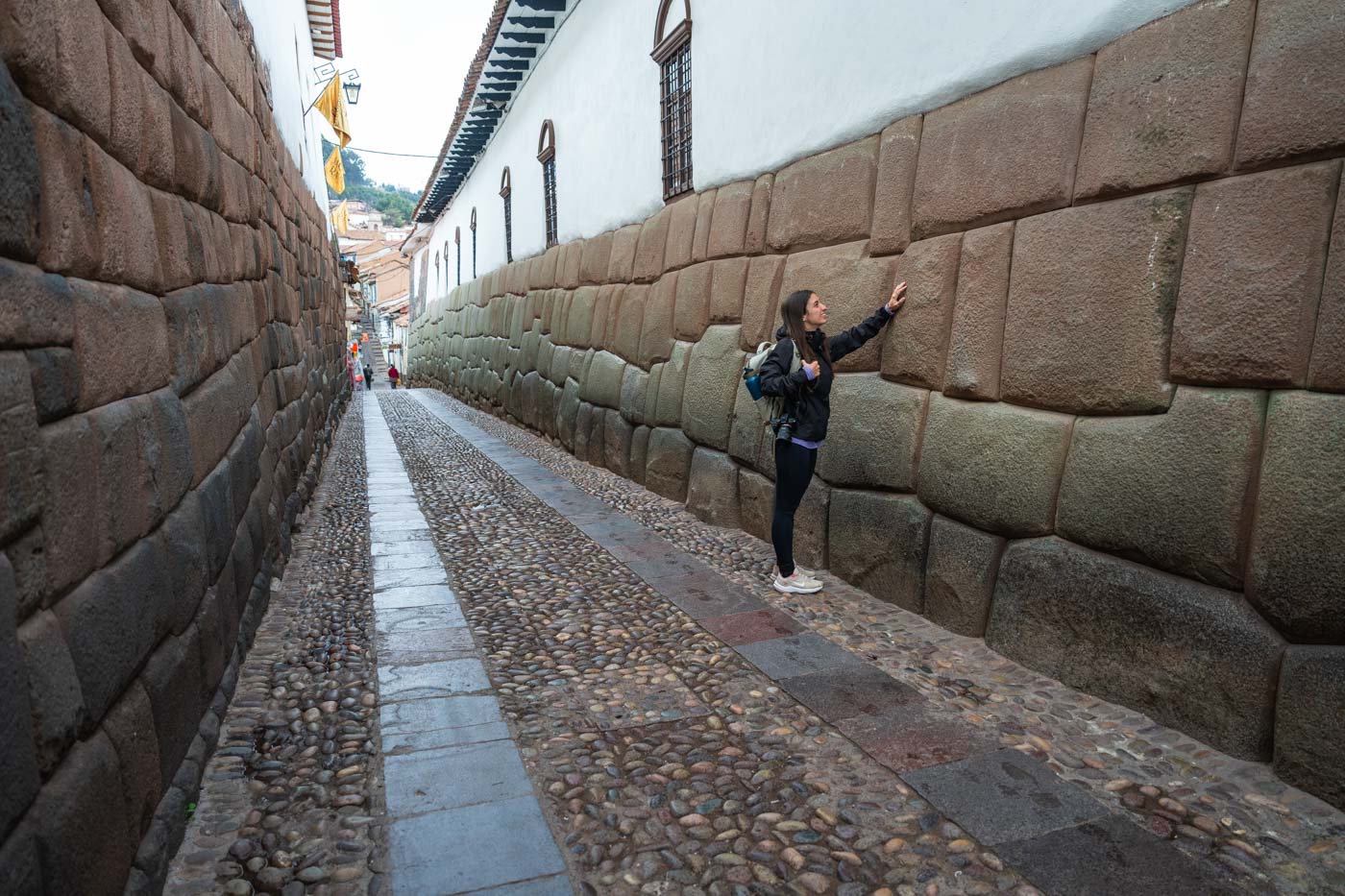 Sara stroking an old Inca wall near the Twelve Angled Stone in Cusco.