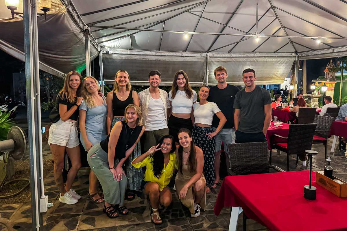 A groups photo of us with out digital nomad friends posing in the middle of Why Not? Italian restaurant in Chiang Mai.