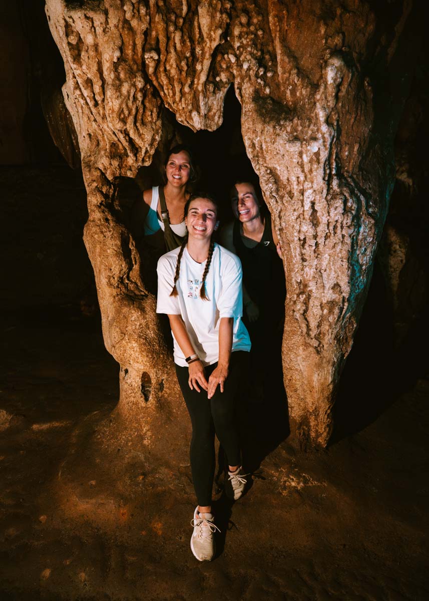 Sara posing for a couple photo with two of our friends inside a hole inside one of Chiang Dao Cave's columns.